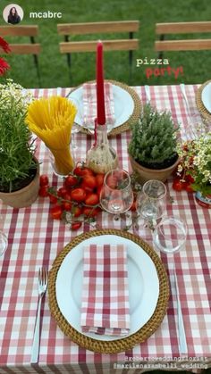 the table is set with plates, cups, and utensils for an outdoor meal