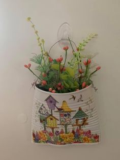 a flower pot hanging on the wall with flowers in it