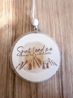 a round ornament that says, spirit lead me when you find a mountain range