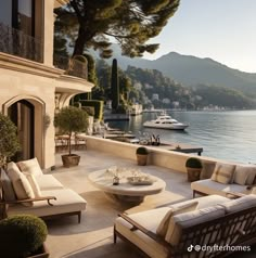 an outdoor living area overlooking the water with boats in the lake and mountains in the background