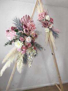 two flowers and feathers are placed on top of an easel