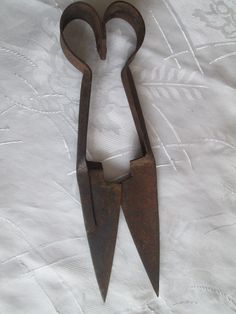 an old pair of scissors on a white sheet