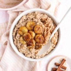 a bowl of oatmeal with bananas and cinnamon sticks