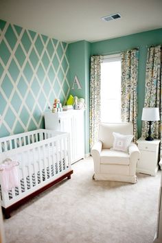 a baby's room with a crib, chair and dresser