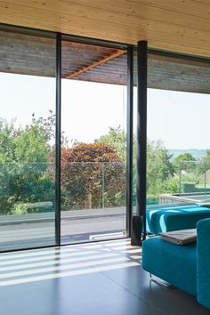 a living room with blue couches and large windows