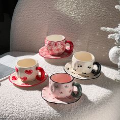 three cups and saucers sitting on a table