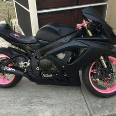 a black and pink motorcycle parked in front of a garage