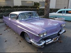 an old purple car parked on the street