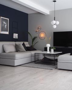 a living room filled with furniture and a flat screen tv mounted on the wall above it