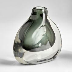 a glass vase sitting on top of a white table next to a black and gray object