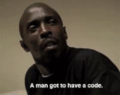 a man is sitting down and looking at the camera with a caption in front of him that reads, a man got to have a code