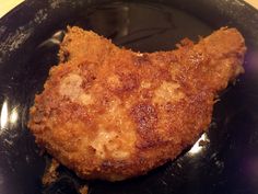 a fried piece of meat on a black plate