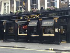 the crown pub in london, england is black with gold trimmings and windows