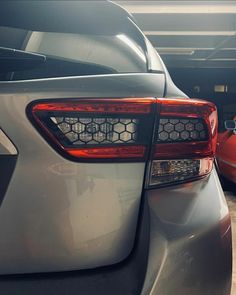 two cars parked side by side in a garage