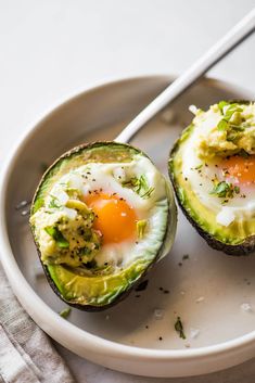 an avocado with eggs in it on a plate