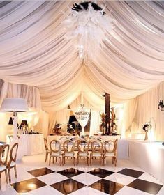 a fancy dining room with white drapes and chandelier hanging from the ceiling