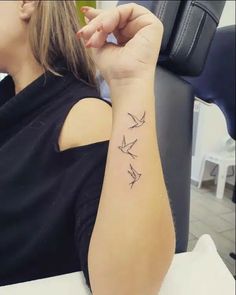 a woman with a bird tattoo on her arm