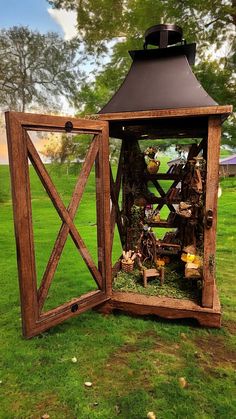 a small wooden structure sitting on top of a lush green field