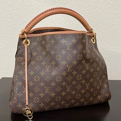 This Is An Authentic, Pre-Owned Piece. This Item Is In Very Good Condition And Shows Signs Of Wear. This Item Shows Minor Wear To Hardware, Very Small Wear To Handle, Pen Stain Inside The Pocket(Picture Included). Artsy Mm In Monogram Canvas With Alcantara Lining And Gold- Tone Brass Hardware Pockets: Six Interior Slip Pockets, One Interior Zip Pocket Measurements: 16.1in Long 8.7in Wide X 12.6in High; 4in Handle All Measurements Were Taken By Hand And Are Approximate; Slight Variations May Occur. Accompanied By Dust Bag And Original Box Vintage Bags With Gold-tone Hardware In Signature Coated Canvas, Vintage Bags In Signature Coated Canvas For Daily Use, Vintage Signature Coated Canvas Bags For Daily Use, Vintage Brown Signature Coated Canvas Bag, Louis Vuitton Artsy Mm, Pen Stain, Louis Vuitton Artsy, Brass Hardware, Monogram Canvas