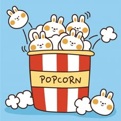 popcorn bucket filled with little bunnies sitting on top of it's sides and the words popcorn written in front of them