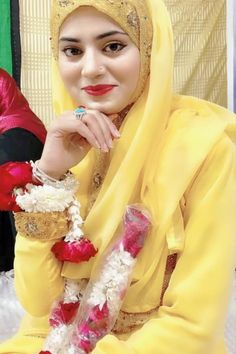 A woman in a yellow traditional outfit, wearing a red and white flower garland, smiles while resting her chin on her hand. Indian Dulhan, Afghan Beauty, Hot Lipstick, Face Veil, Dating Women, Arabian Beauty Women, Beautiful Muslim Women, Arab Women, Beautiful Women Over 40