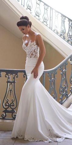 a woman in a white wedding dress standing on the stairs with her hand on her hip