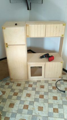 an unfinished kitchen cabinet with tools on it