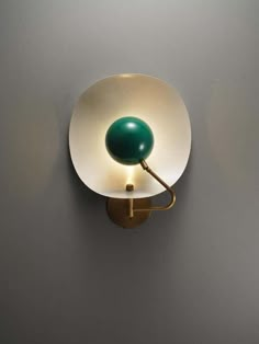 a wall light with a green ball on it