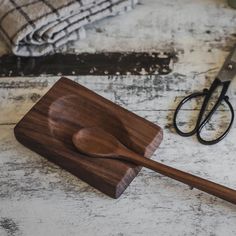 a cutting board with a wooden spoon on it next to a pair of shears