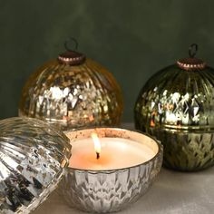 three decorative glass candle holders sitting next to each other