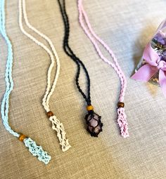 three necklaces with beads and tassels on a table