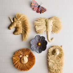 The perfect statement piece for little animal lovers, our enchanting lion wall art is handwoven of natural raffia. Kids will love the charmingly oversized main and sweet smile. These raffia animals are handcrafted by a women's cooperative in Uganda, which provides artisans with fair wages for their families.   • Artist: Brandon "B" Arnold  • This is not a toy  • Not to be used within baby's reach or directly above crib  • Raffia and metal  • Spot clean only  • Made in Uganda All Across Rattan Animal Head, Gold Animal Head Wall Decor, Safari Toddler Room, Unicorn Head Wall Decor, Blue Flowers Decor, Africa Elephant, Animal Head Wall Decor, Unicorn Wall Decor, Head Wall Decor