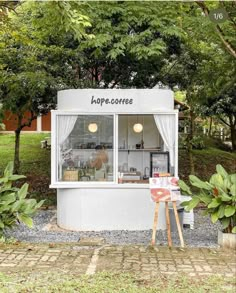 a small white building with a sign that says hope coffee on the front and side