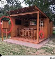 an outdoor bar with wooden chairs and bars on the outside, surrounded by green grass