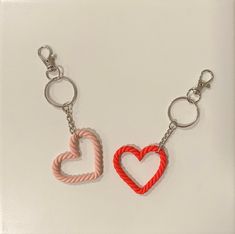 two heart shaped key chains on a white surface