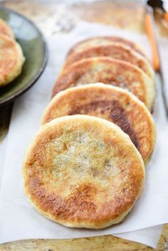 some pancakes are sitting on top of a paper towel next to a black plate and utensils