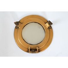 an image of a porthole mirror on the wall in gold color with white background