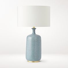 a blue ceramic lamp with a white shade