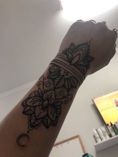 a person's arm with a tattoo on it and a clock in the background