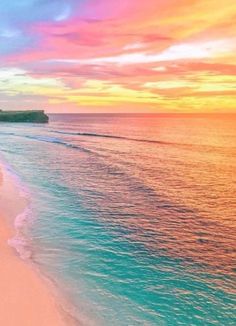 the beach is lined with white sand and blue water as the sun sets over the ocean