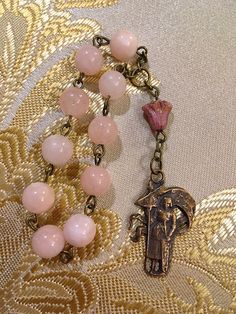 Handmade vintage French style bronze St. Joan of Arc single decade Rosary made with 8mm pink Jade gemstone beads, a pink Czech glass Lily and an antique reproduction solid bronze St. Joan of Arc medal. Bronze Rosary As Gift, Bronze Rosary With Round Beads As Gift, Antique Jewelry With 8mm Beads For Gift, Antique Jewelry With 8mm Beads As Gift, Antique 8mm Beads Jewelry As Gift, Vintage Rosary With Round Beads As Gift, Vintage Bronze Rosary As Gift, Vintage Beaded Rosary As Gift, Antique 8mm Beads For Jewelry Making