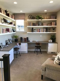 a home office with two desks and shelves full of books on the top shelf