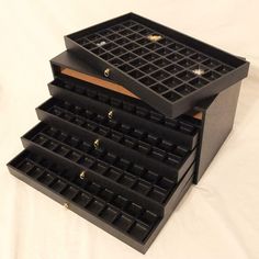 three black jewelry boxes stacked on top of each other with gold studs in them