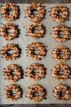 chocolate covered pretzels are lined up on a baking sheet