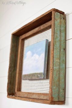 a painting is hanging on the wall next to a white brick wall and wooden frame