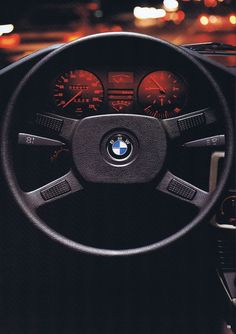 the interior of a bmw car with dashboard lights and gauges showing at night time