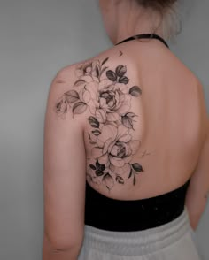 the back of a woman's shoulder with flowers on it