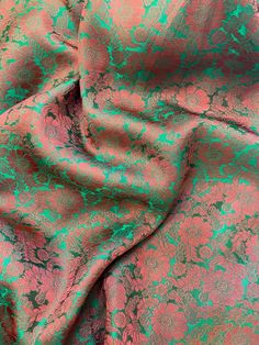 a pink and green fabric with small flowers on the top, as if it were brocaded