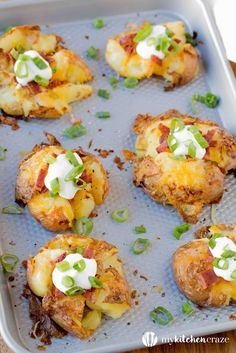 baked potato skins with sour cream and green onions on a baking sheet, ready to be eaten