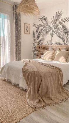 a bedroom with a palm tree mural on the wall and a bed covered in beige linens